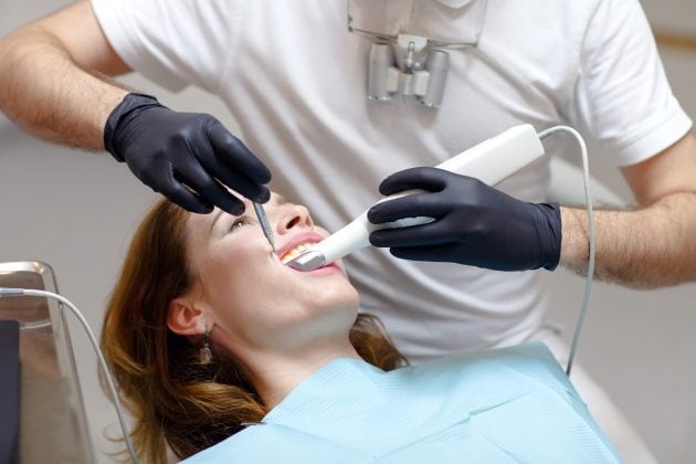 Patientin mit 3D-Scanner im Mund.